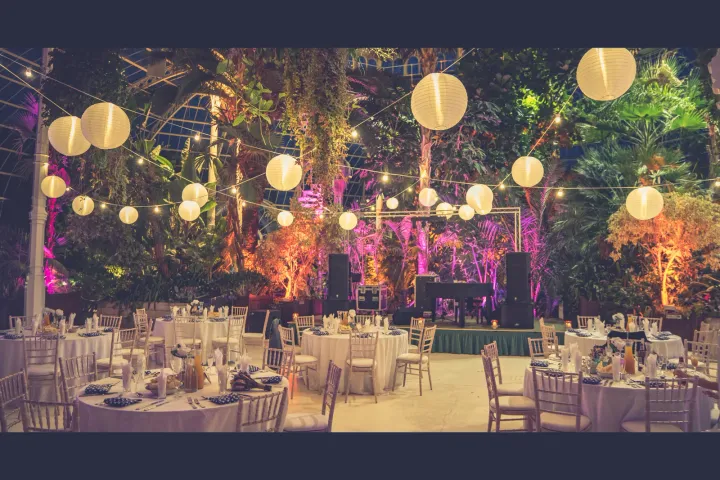 Glasshouse reception with glowing hanging lanterns