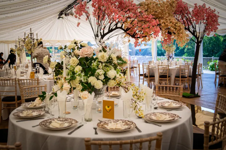 Floral table styling beneath decorative blossom trees