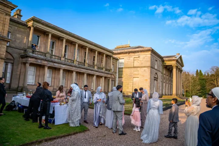 Guests gathering outside a stately house