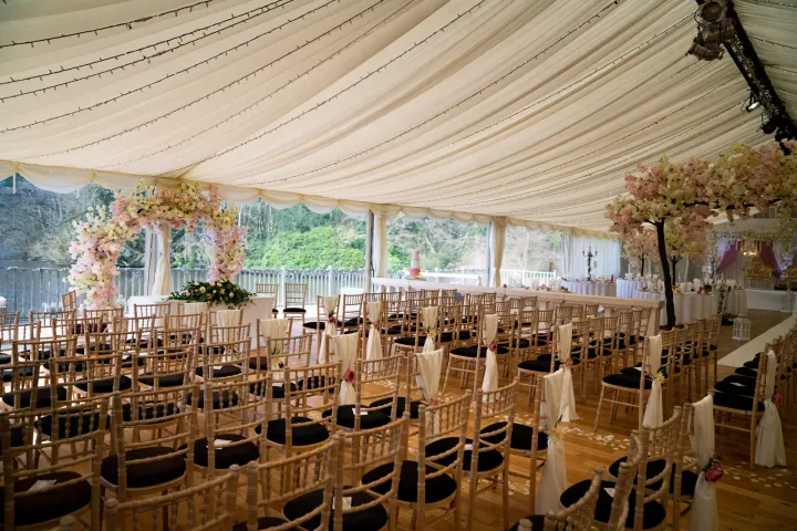 Ceremony chairs arranged beneath white marquee draping