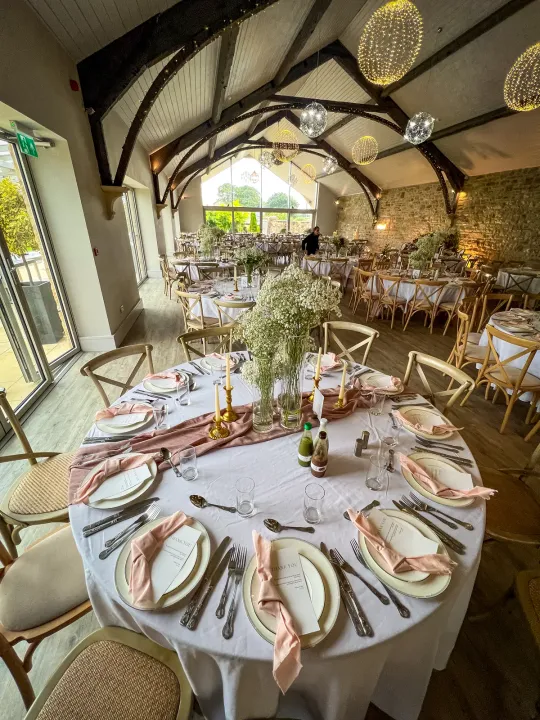 Round table setting in a timber-framed room