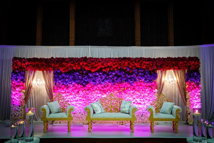 Wedding seating before a vivid flower wall