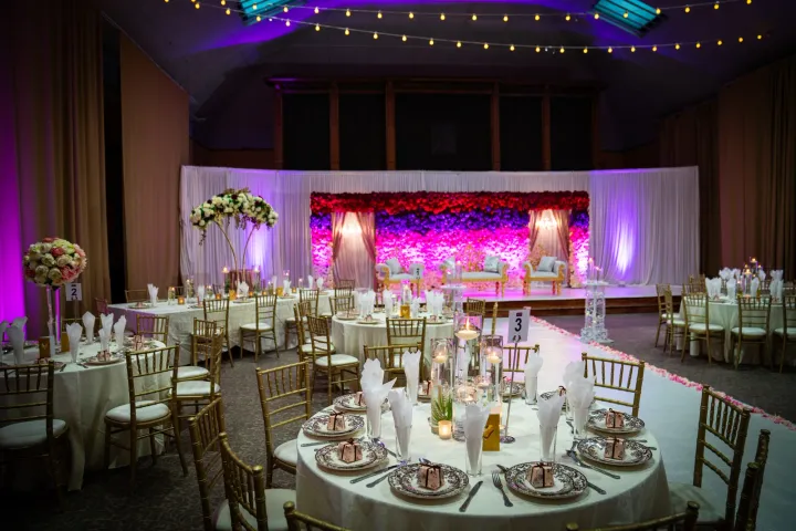 Reception hall with a pink-lit floral stage