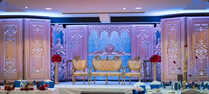 Gold wedding seating beneath an ornate backdrop