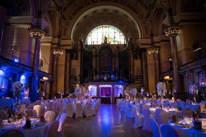 Reception tables under blue lighting in a grand hall