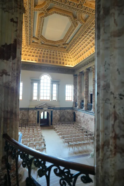 A sweeping staircase overlooking a historic ceremony room